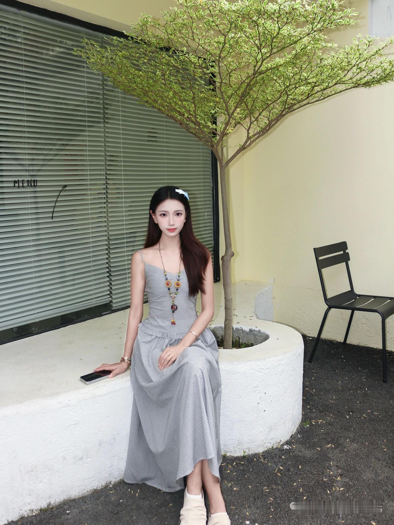 记录我的2026恢色连衣裙少女倚石而坐，角落背后绿植遮阴处，享受宁静时光。