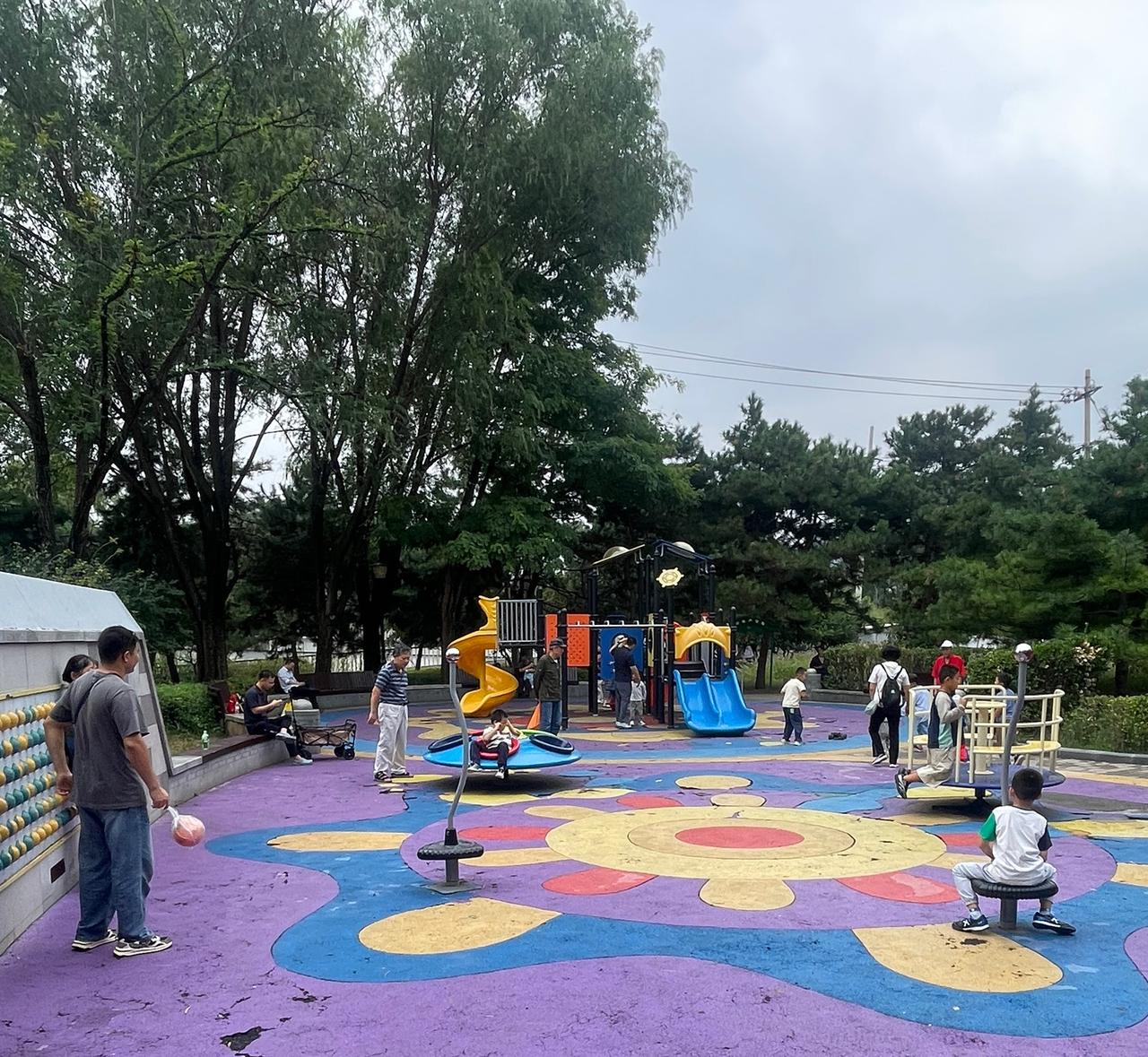北京玲珑公园的儿童活动区，是京城宝藏免费遛娃地。大片紫蓝拼色防滑地垫，黄色、蓝色