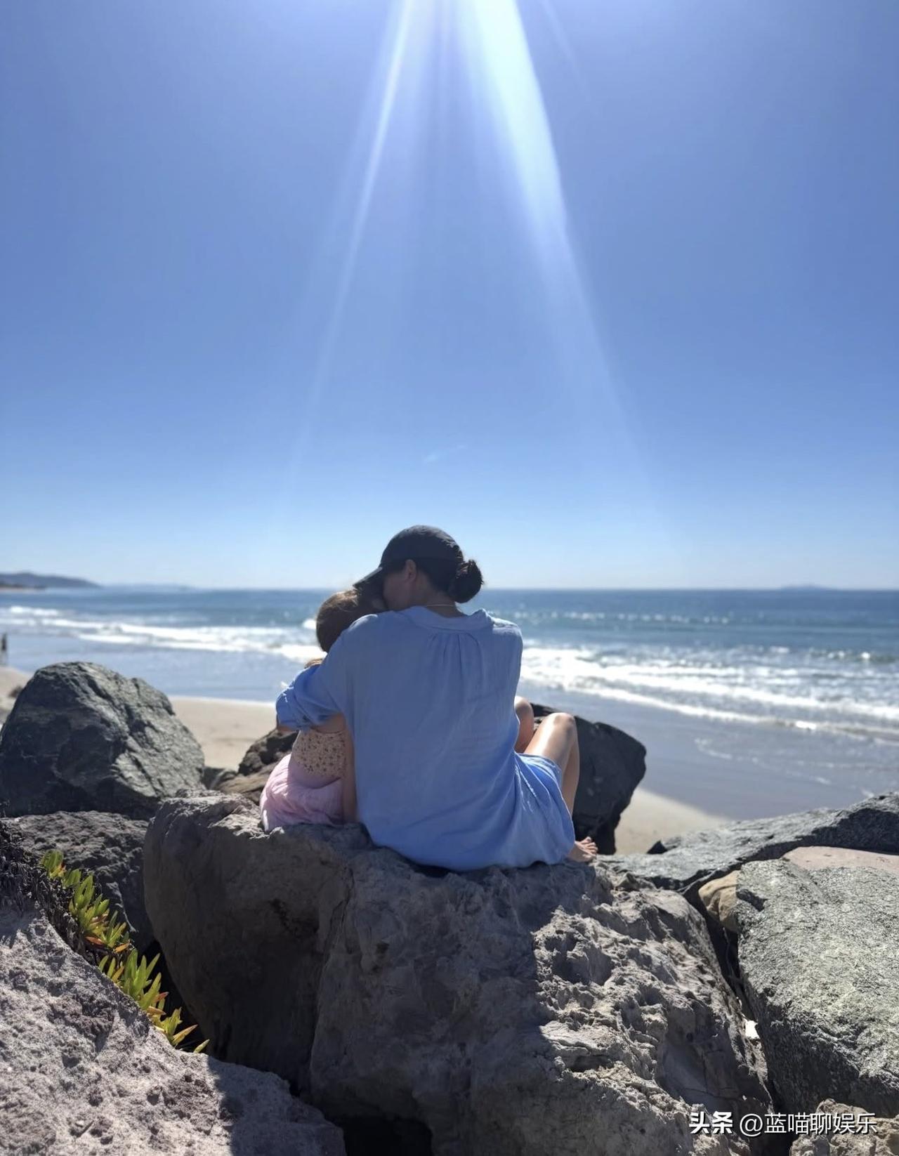 梅根分享与莉莉贝特的海边合照庆祝国际妇女节，她抱着4岁的女儿，由哈里拍摄。
网飞