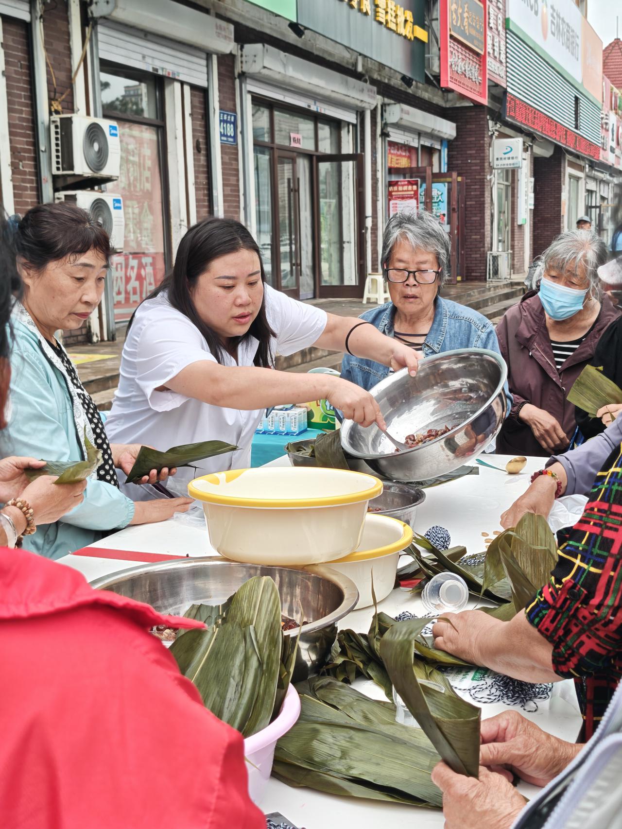 下午出来买东西，一家药店门前热闹异常。走近一看原来是端午节将至，进行包粽子比赛。