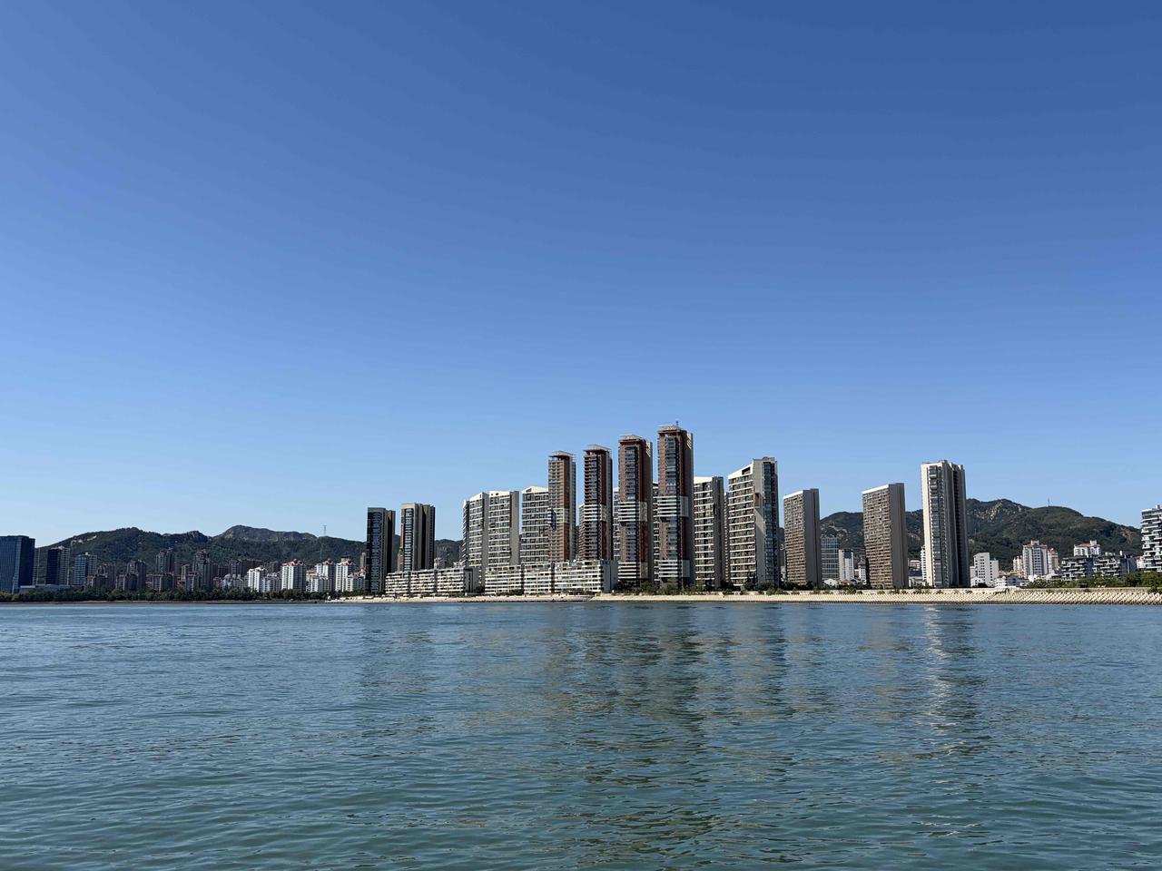 乘船远眺威海，山海城市一眼尽收

坐船航行在海上，望向威海岸边，成片高楼沿着海岸