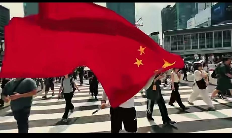 一个中国小伙子拿着五星红旗在日本东京街头飘扬。大街上没有一个日本人敢站出来制止，