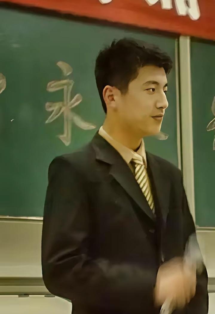 这是张雪峰在郑州大学主持活动的旧照，西装挺拔、眉眼清朗，站在台上自信从容，妥妥的