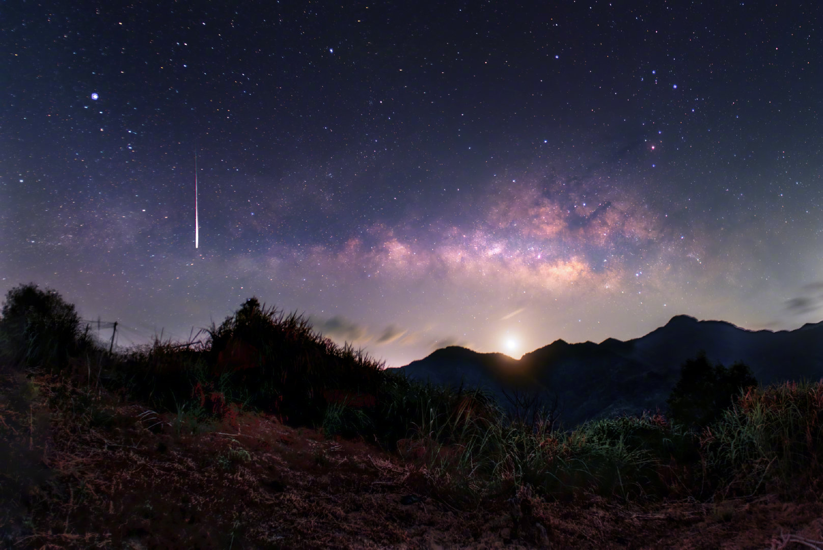 情人节凌晨的岭南山巅，夜空深邃而温柔。横跨天际的璀璨银河与缓缓升起的明月，构筑起