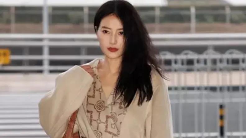 高圆圆以一袭米白色大衣优雅亮相机场，仿佛冬日里的一抹温柔阳光，令人眼前一亮。她身