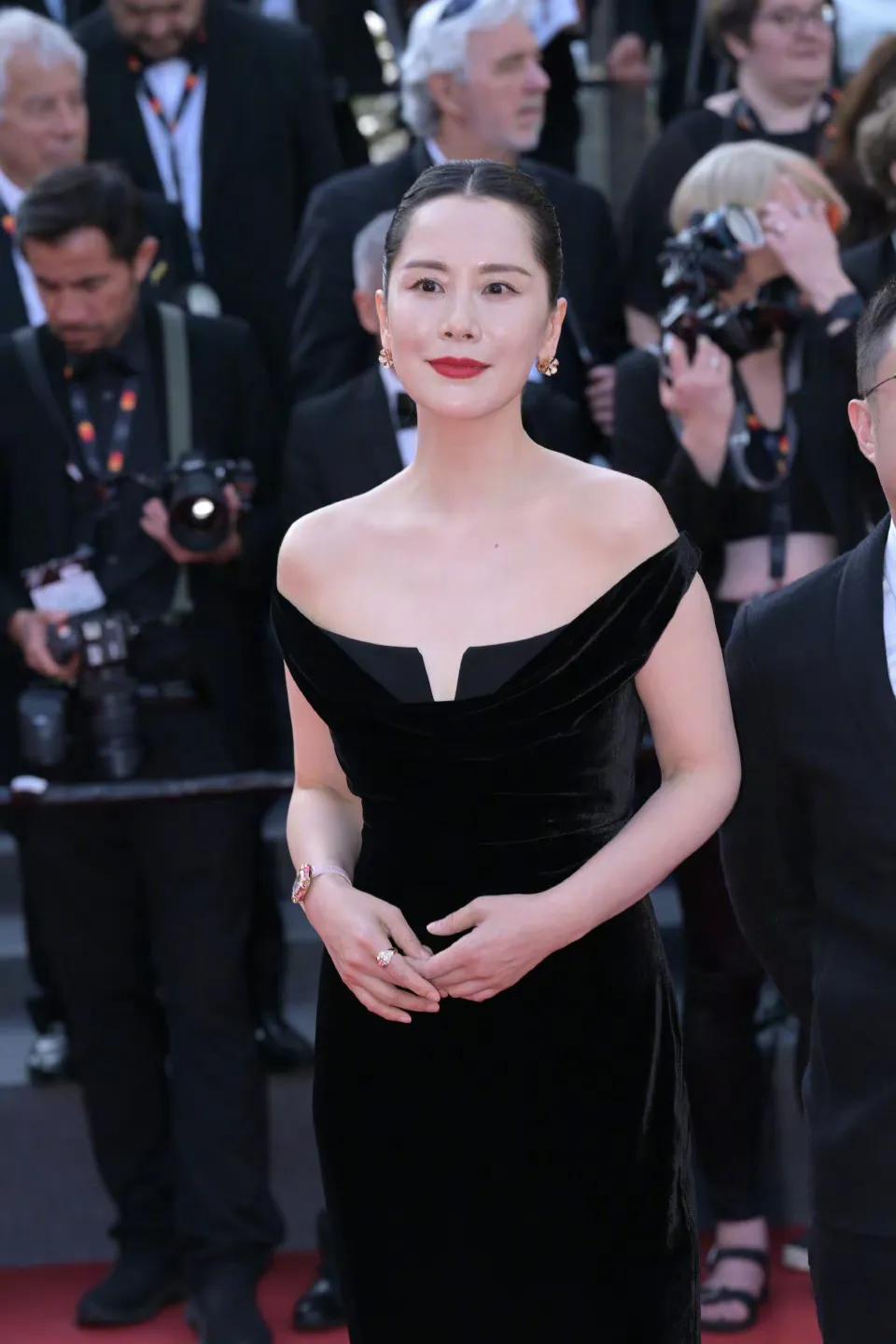 海清在戛纳电影节红毯上身穿黑丝绒露肩礼服，感觉她胖了，也许是生图的缘故，没有她在