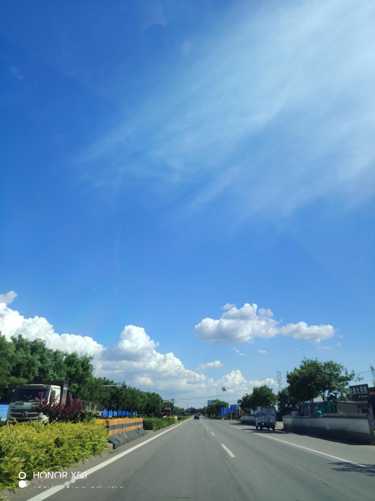蓝天白云下的公路，行驶在自由的道路上，感受风的自由。