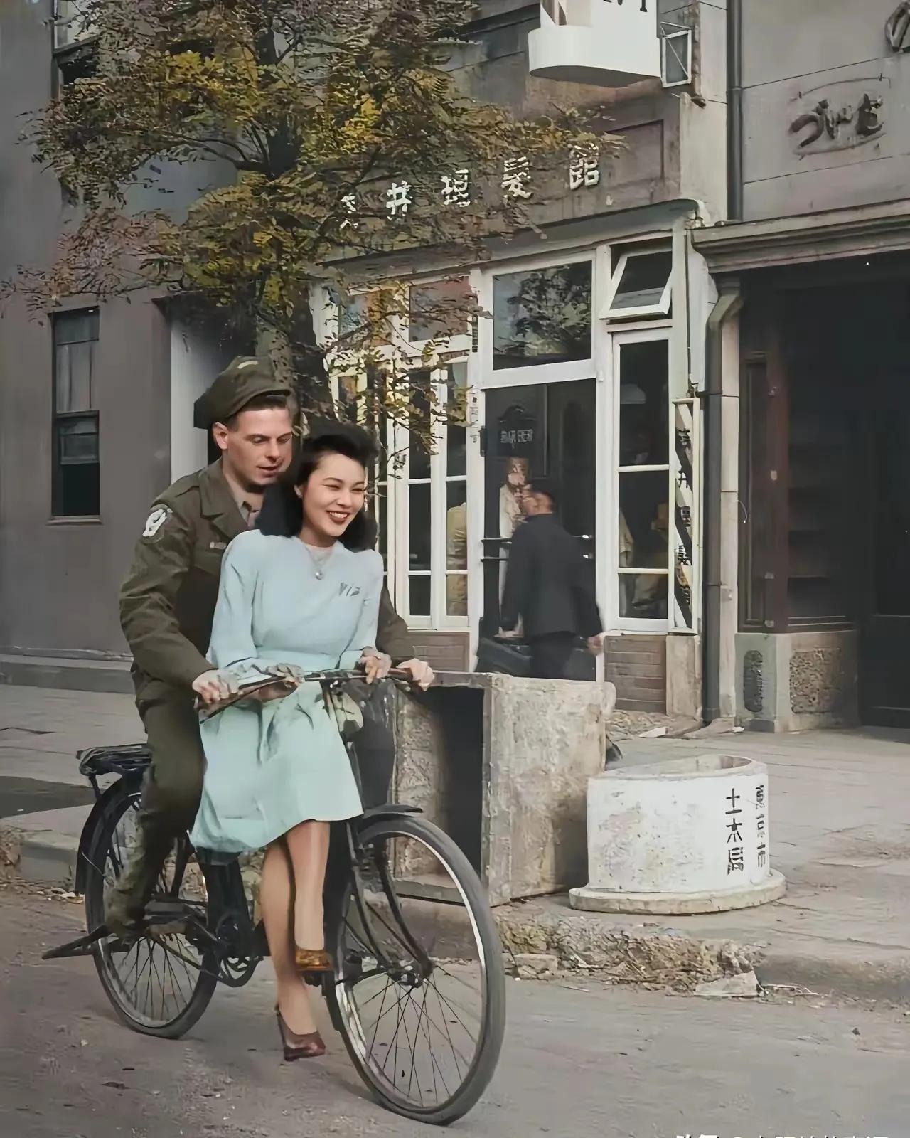 二战时期故事：这张照片拍摄于1946年，驻日美军在和当地的一名女士悠闲的骑着自行