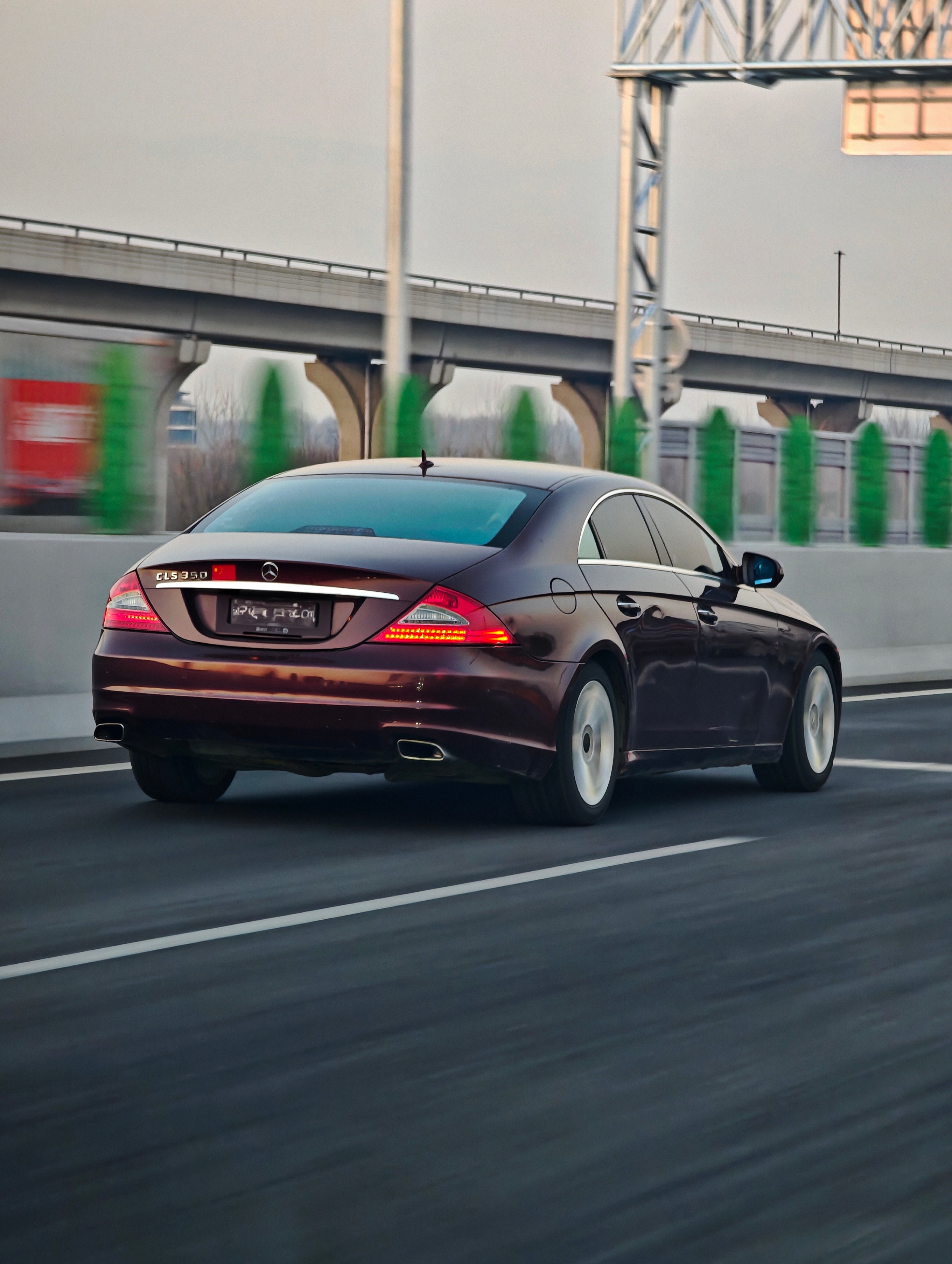 傍晚高架上遇到一台疾驰的酒红色初代CLS夕阳洒在车身上，它像极一位散发着魅力的优