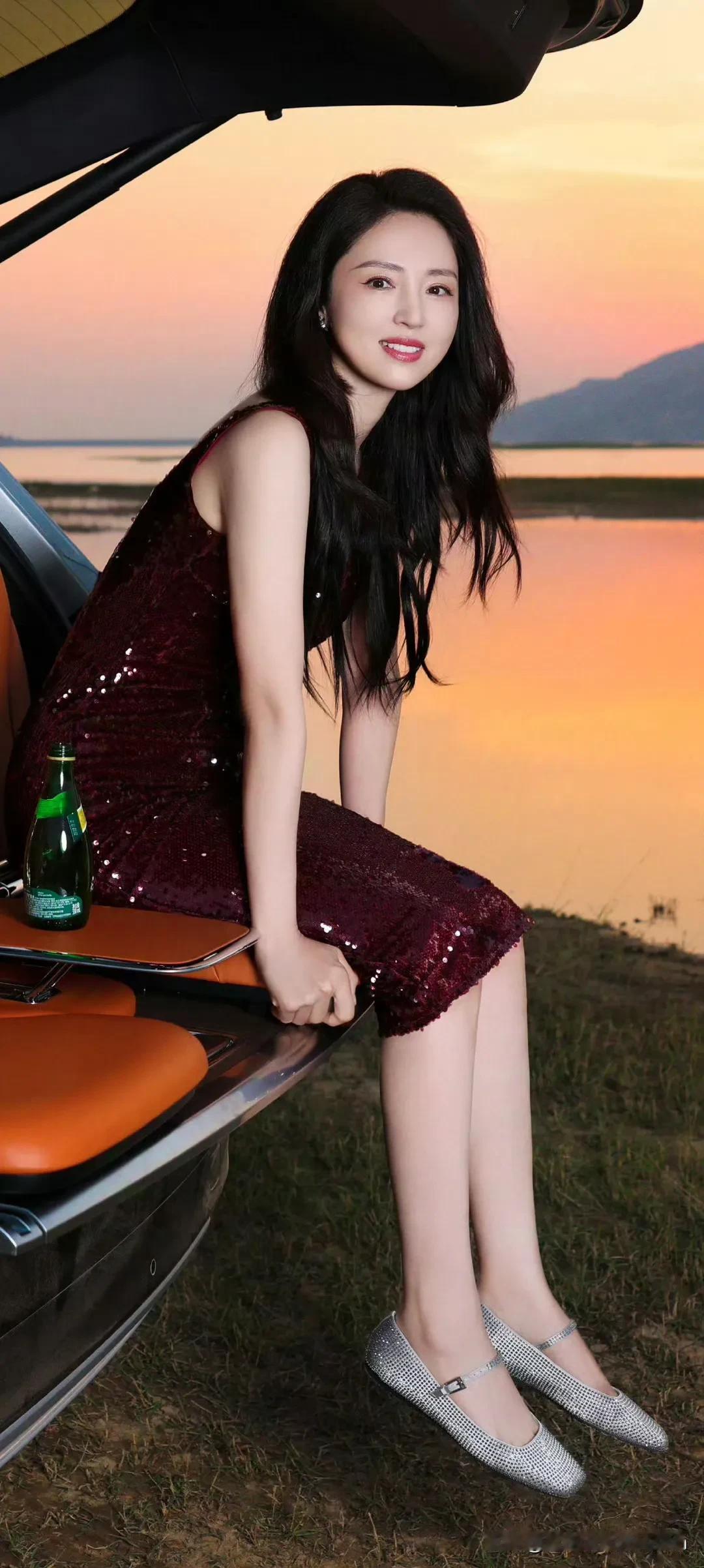 董璇夕阳下的优雅瞬间，闪烁的裙摆与宁静的湖面相映成趣