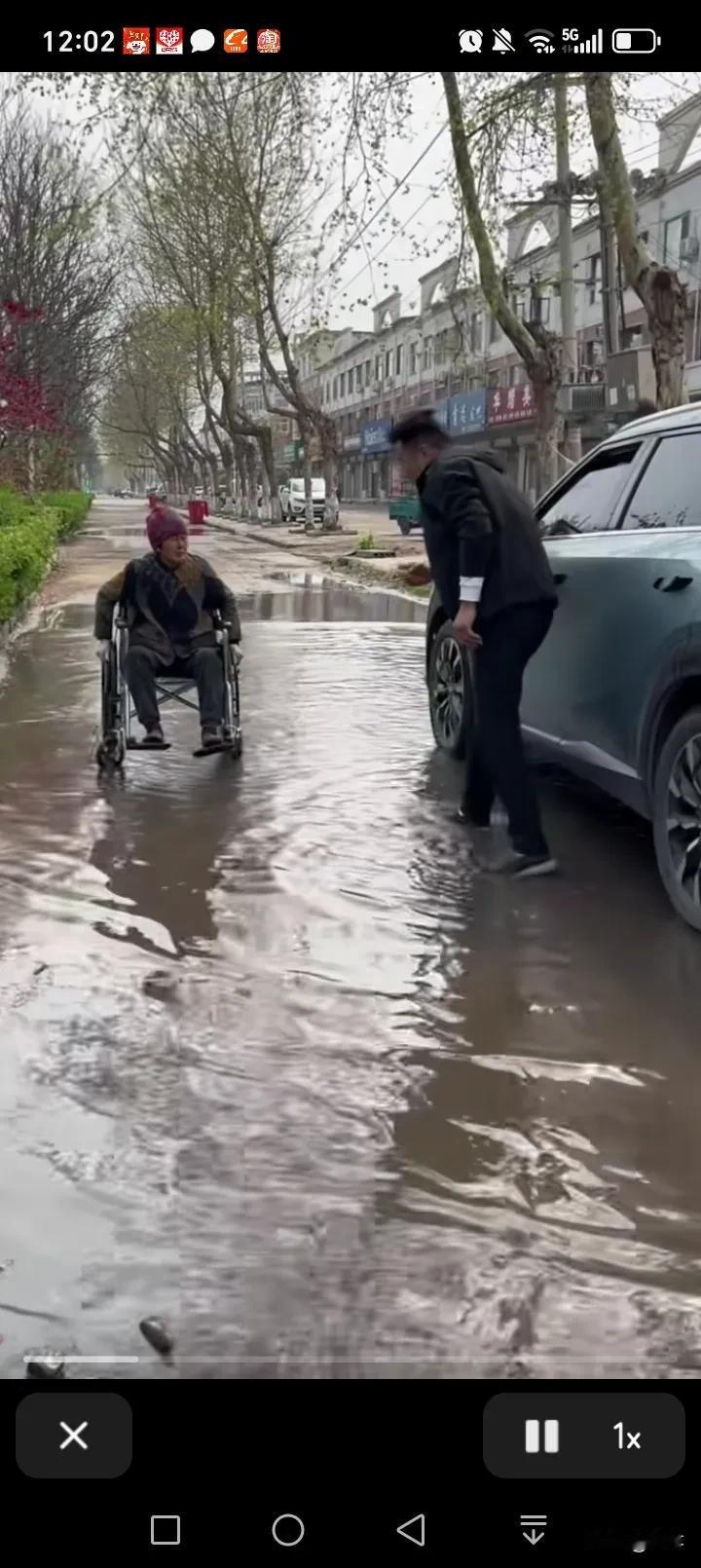 下班的路上，雨水把路面淹没了，有位老奶奶自己推着轮椅，进退两难，这时，车上有一位