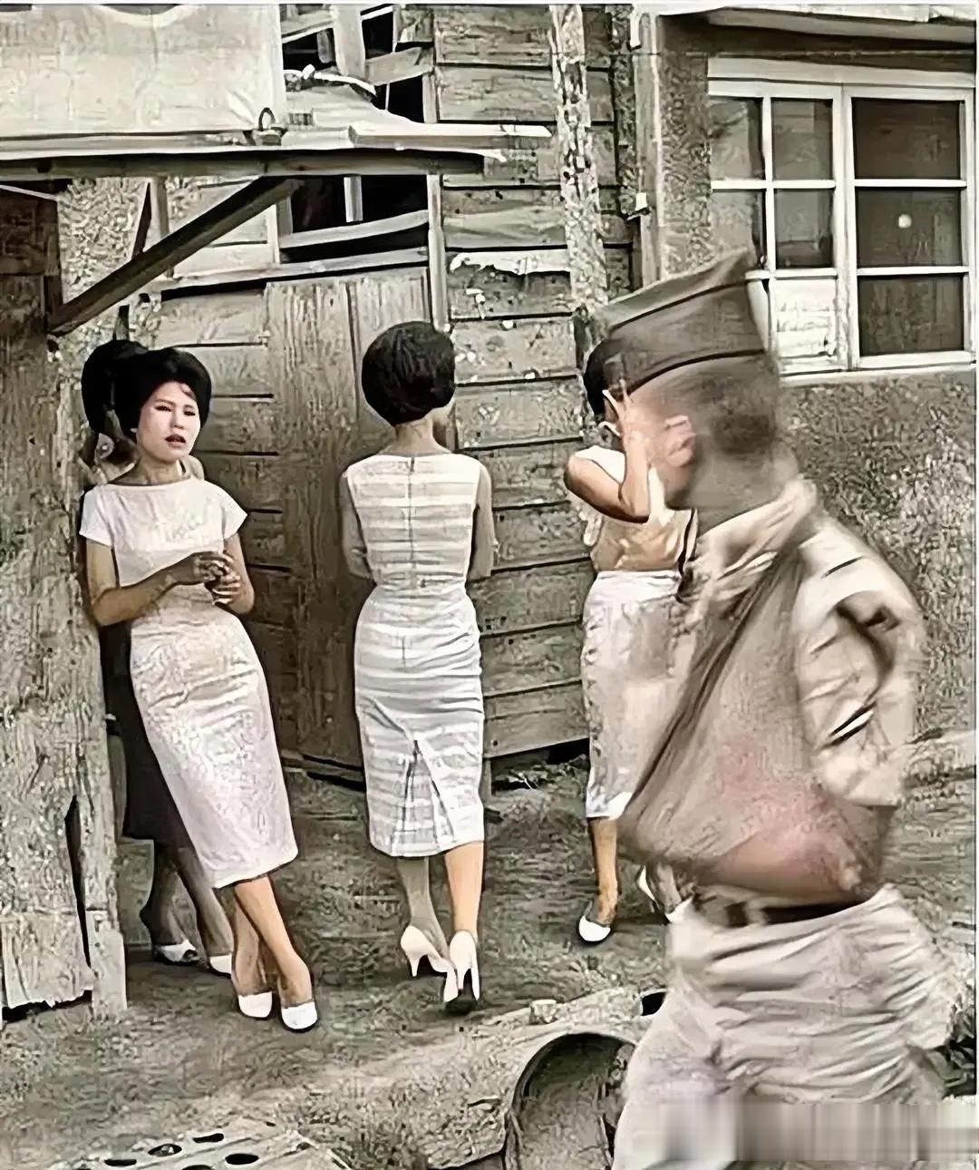 50年代，在日本东京，站在街边的慰安妇正在向一名受伤的美军抛媚眼。
照片中，几名