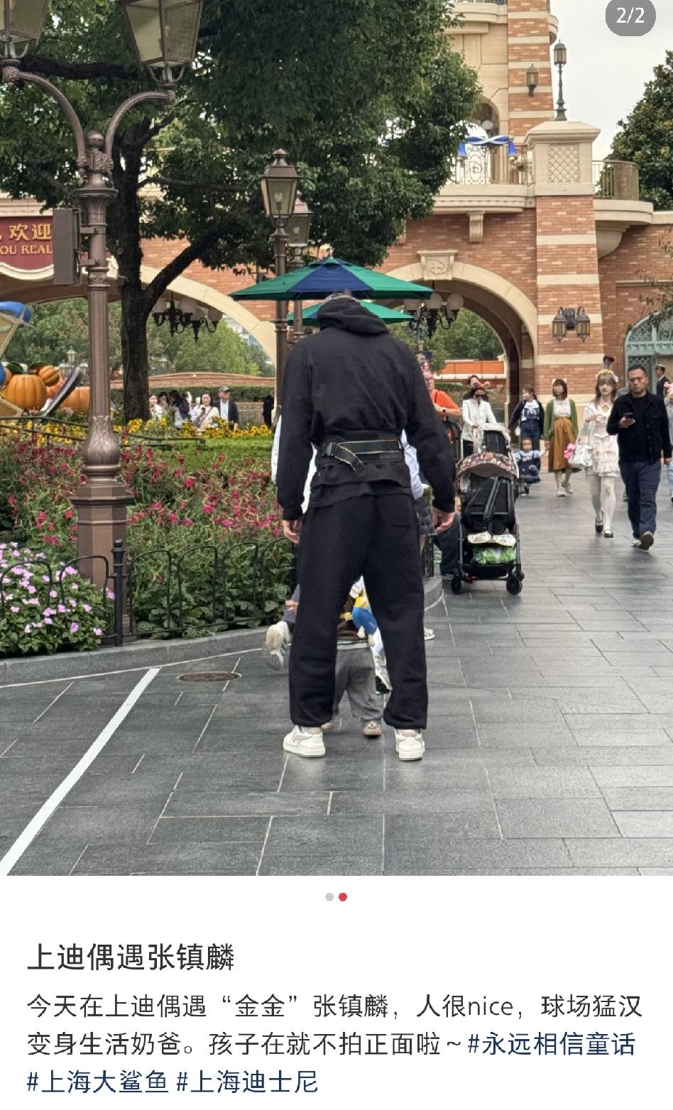 网友在上海迪士尼偶遇张镇麟带着老婆孩子游玩，张镇麟穿着一身黑色运动服戴着一顶黑色