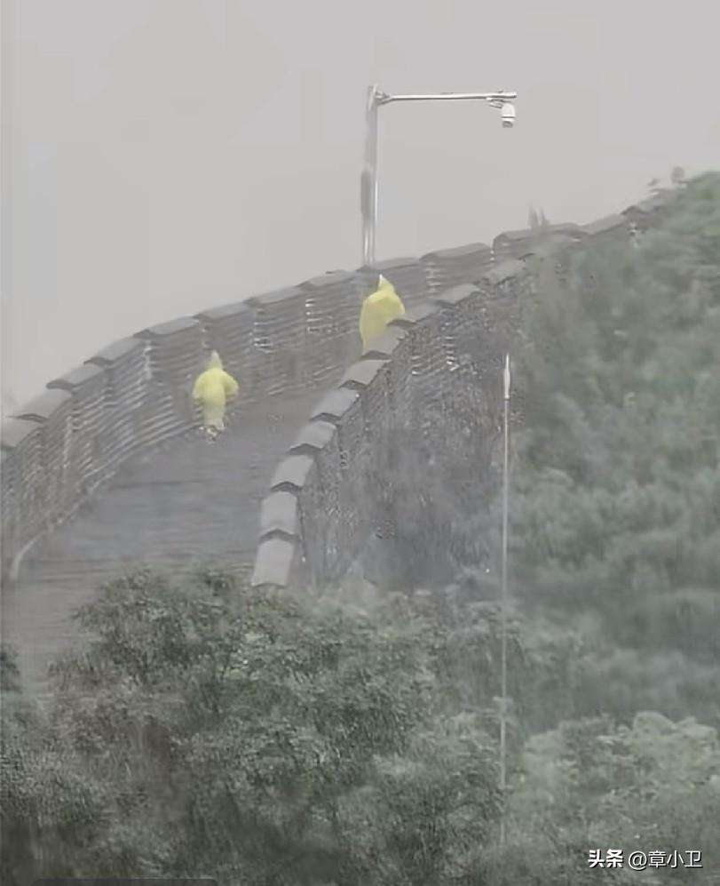 近日北京，突降大雨，一对父亲领着小孩顶着风雨爬长城，行为引发网友争议，有的夸赞父