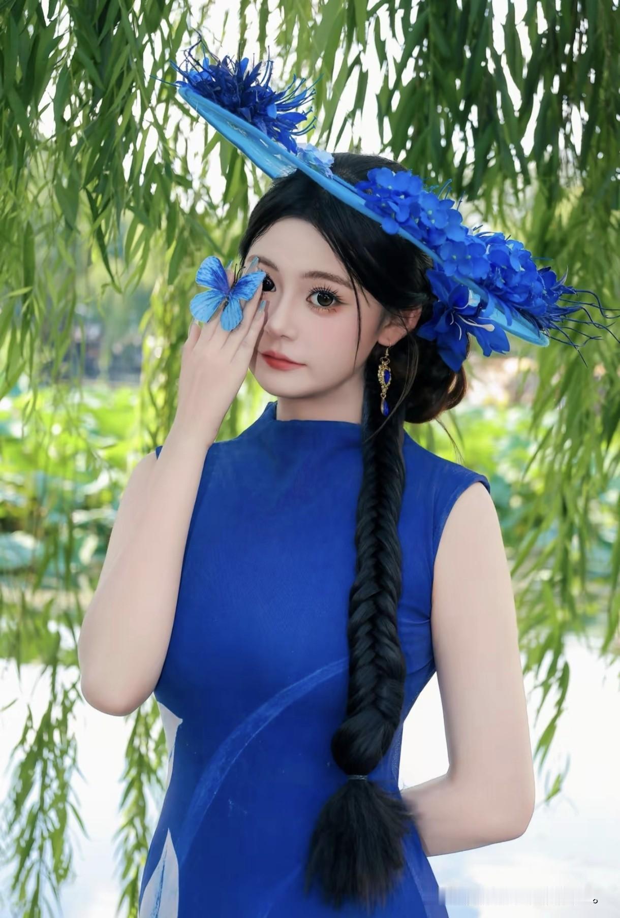蓝裙少女与蝴蝶共舞，柳荫下定格春日浪漫，仿佛童话里走出的精灵般灵动迷人。蓝裙少女