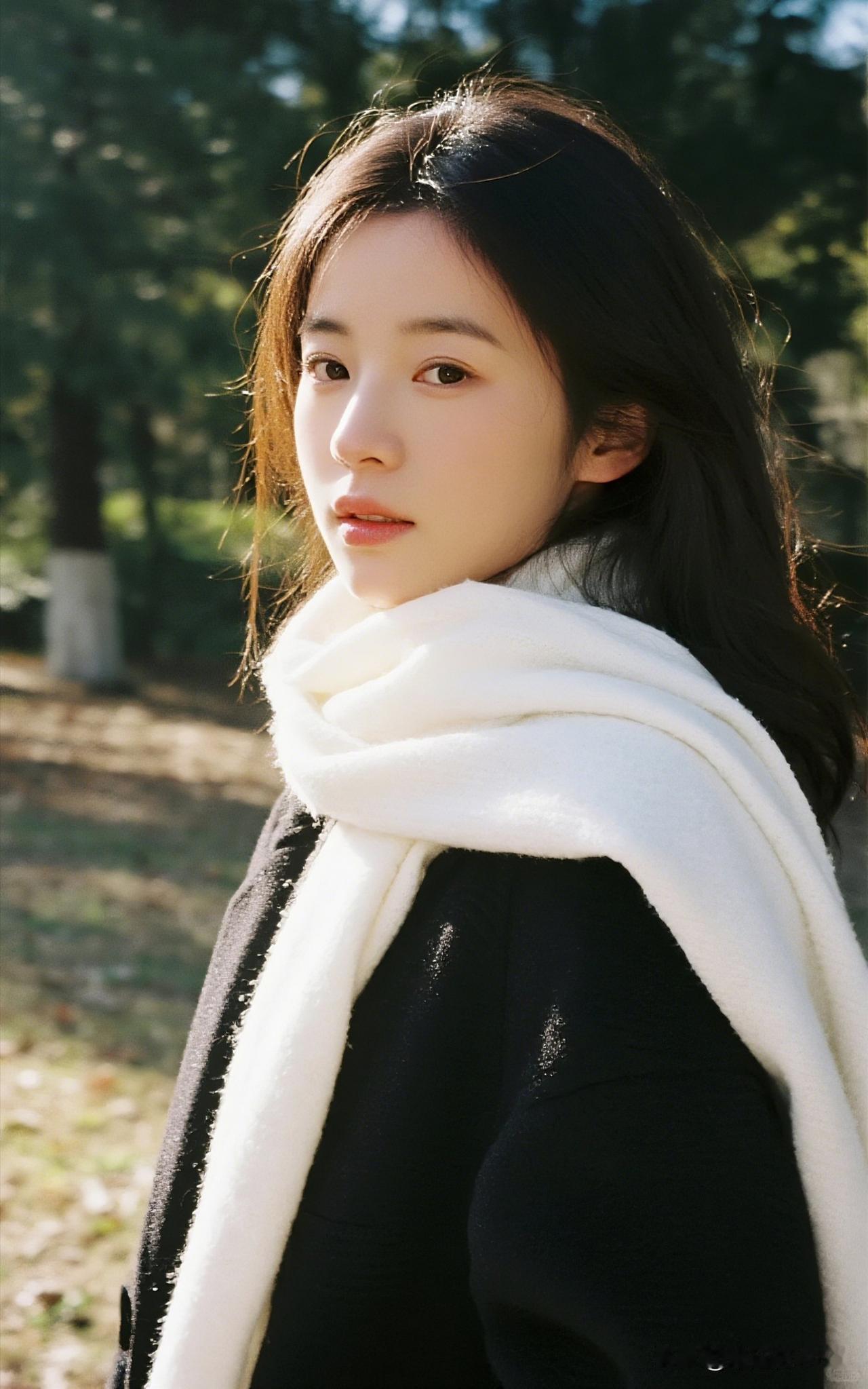 风把秋天揉碎在她发梢时，围巾成了季节最软的注脚。
第一张里的格纹款裹着焦糖与深棕