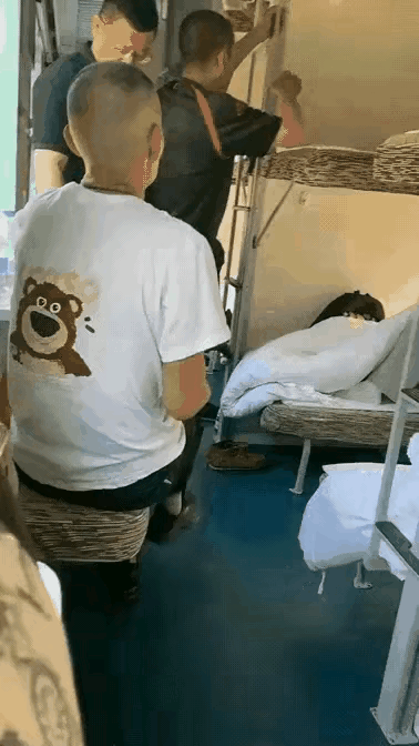 惊呆了！居然有人乘火车不会睡卧铺，一男子爬上中铺后，本该靠墙坐，他却向外坐，结果