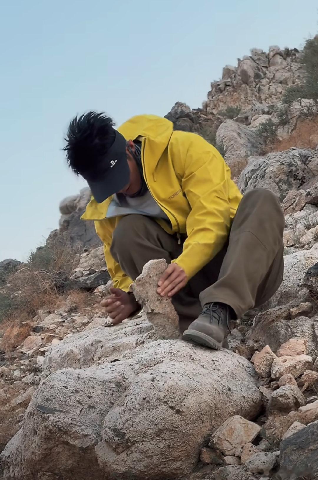 黄景瑜蹲在山上敲石头 旷野爬山随手玩石头，随性自在黄景瑜手黢黑 ​​​
