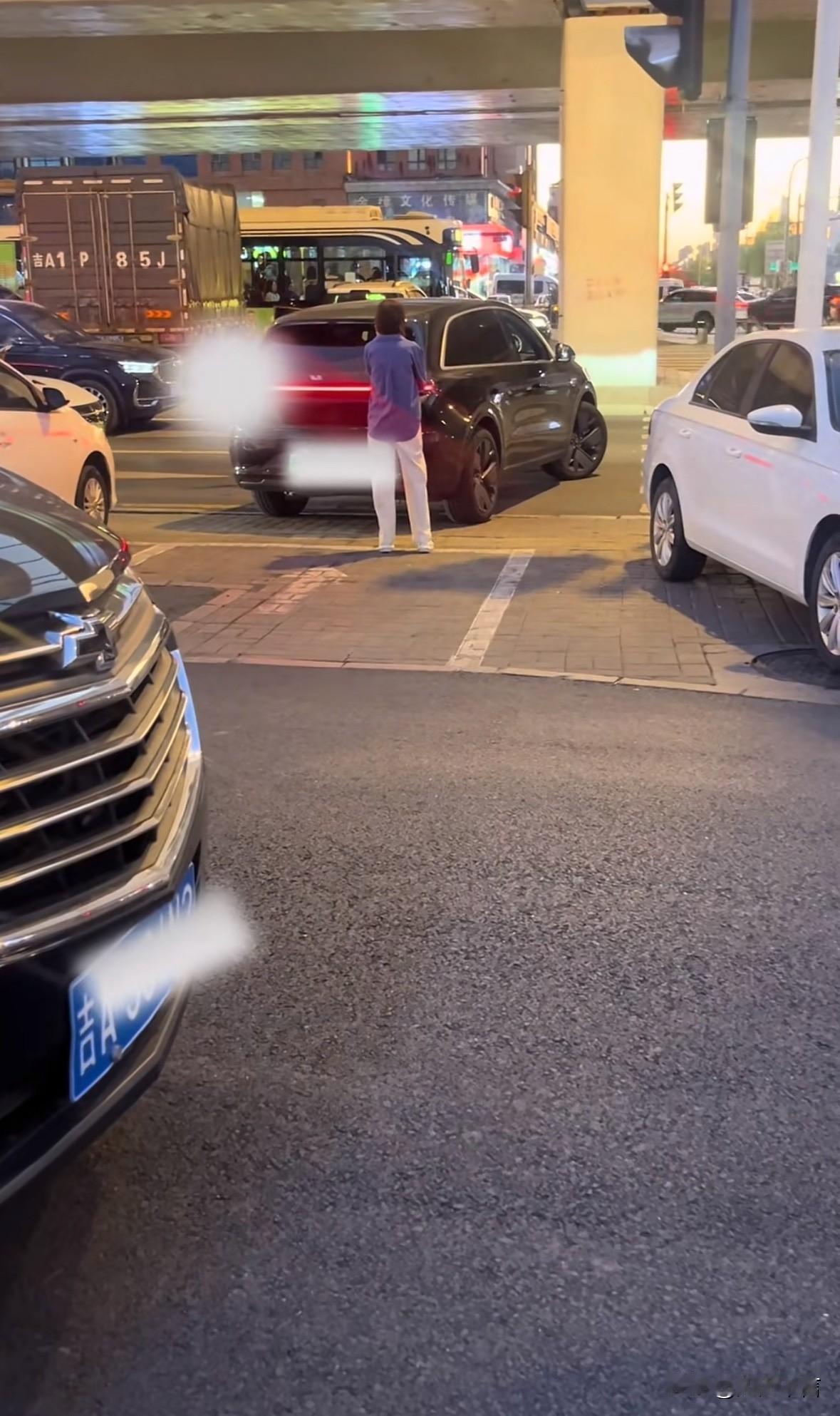 “人肉占车位”太可气了！这个女的占车位估计有一个小时了，中间不断有车来，她就是站