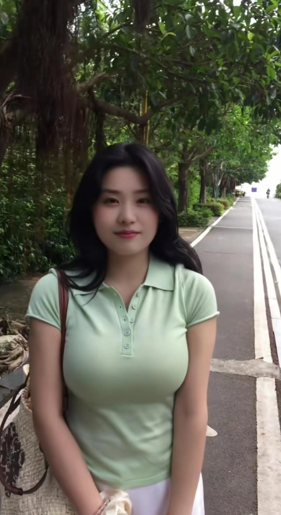 一个女孩站在绿树成荫的小路上。