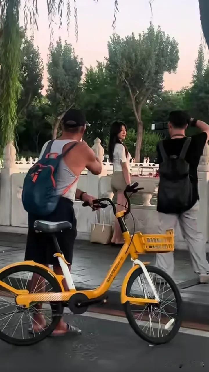 “螳螂捕蝉，黄雀在后”，摄影师给美女拍照，大爷也趁机拍了几张，又有人拍到大爷和摄
