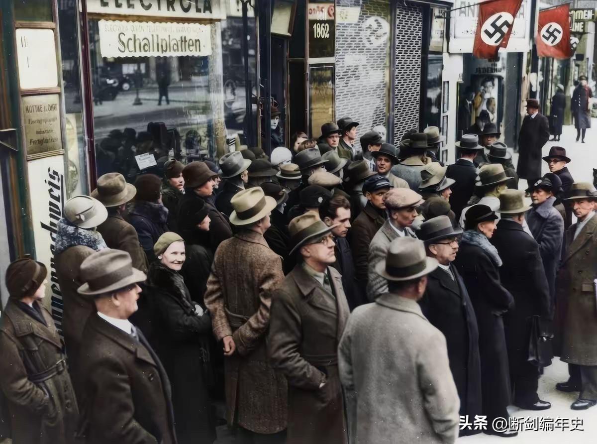 1939年9月1日，柏林弗里德里希大街，一群市民聚在一家收音机店前，收听德军入侵