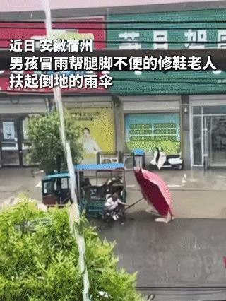 腿脚不便修鞋老人的雨伞被风吹倒，一男孩看到后，冒雨过来帮忙扶起雨伞。男孩自己没带