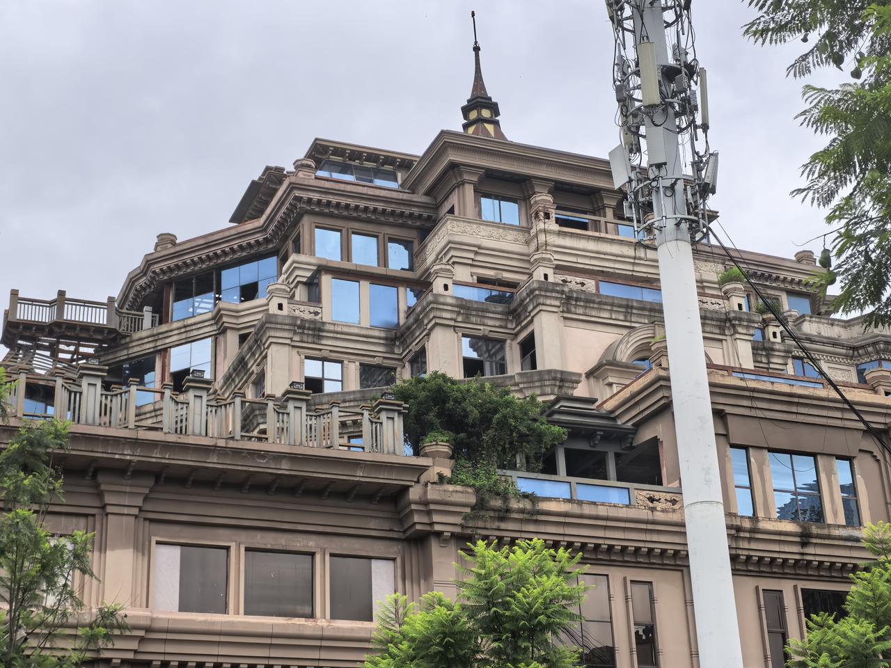 昆明西山区滇池路上的这个楼顶上还装置了一个直升机低空飞行器，这座超级别墅有五十米