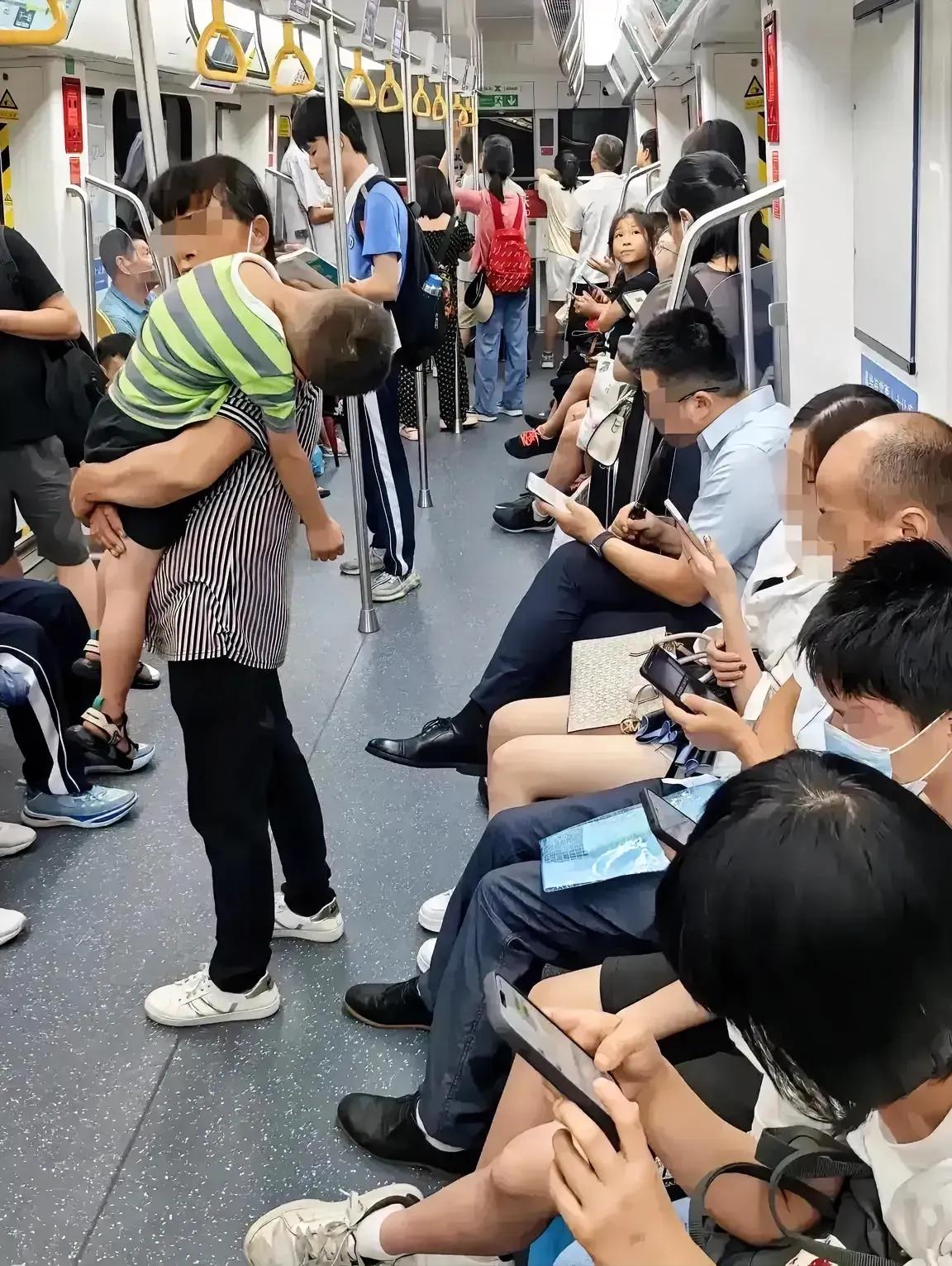 地铁上一个站着的母亲，抱着睡着的孩子，这一幕看上去让人感觉有些心酸。
心酸的不是