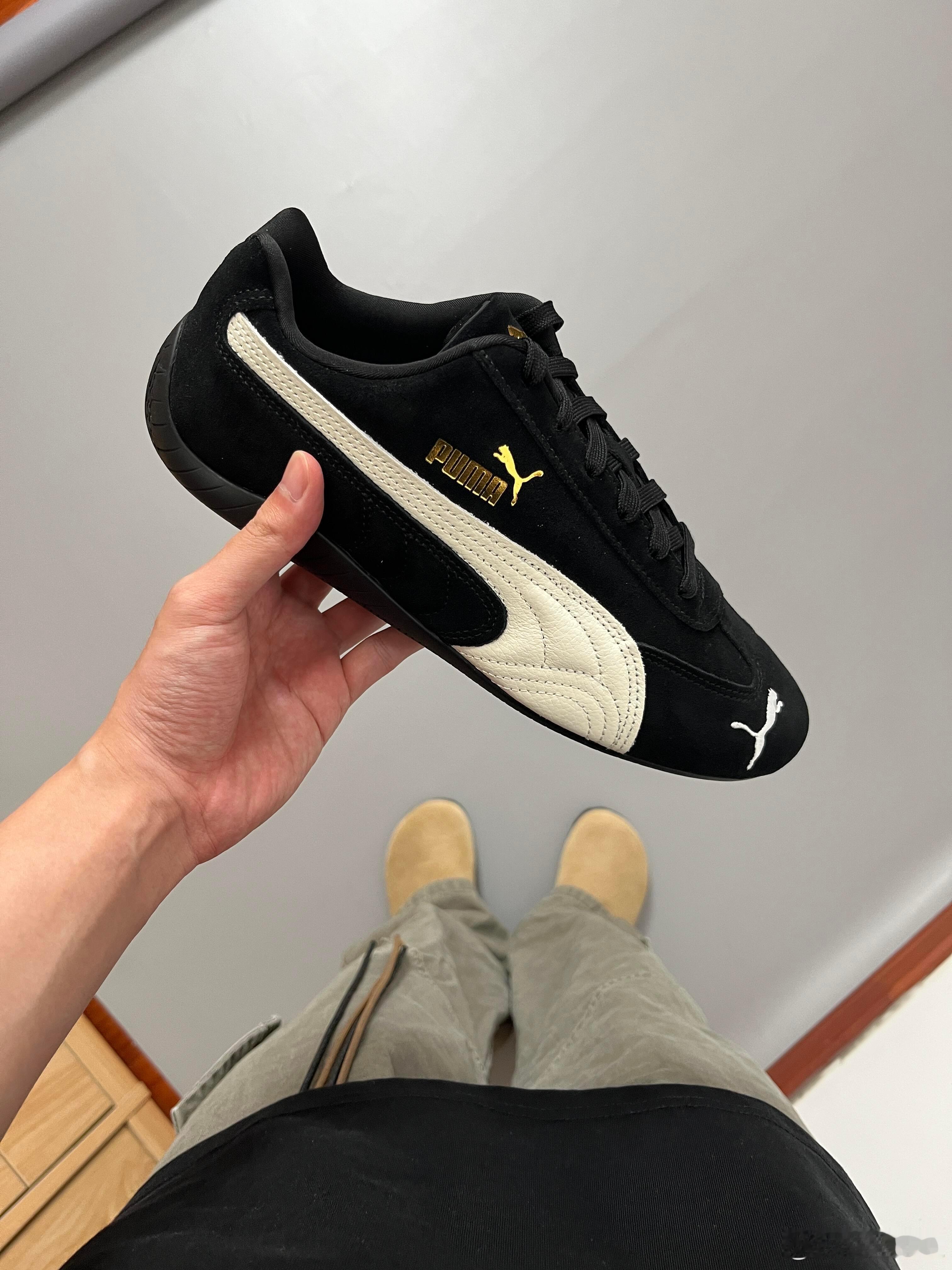 PUMA赛车鞋以其经典的黑白配色与醒目的金色标识，展现出浓郁的复古运动风格。鞋身