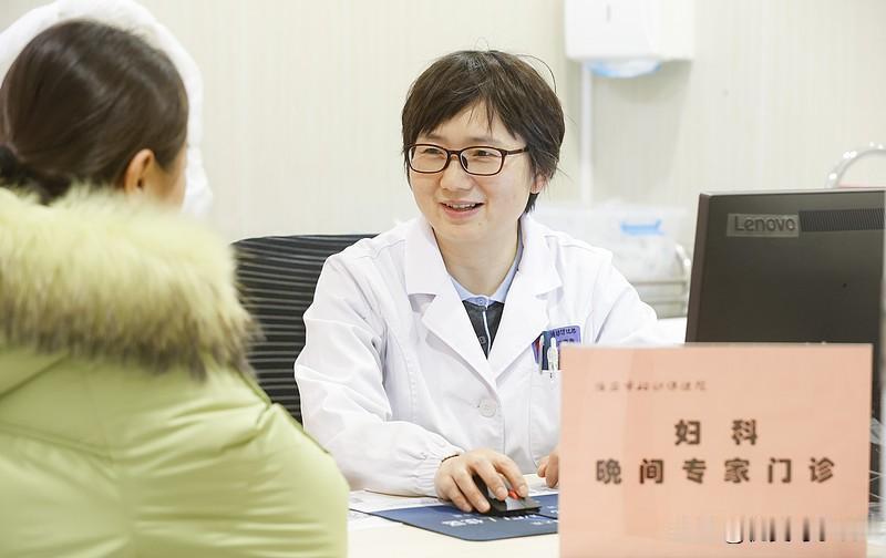 医生正在和病人交流。一旁的实习护士悄悄把科普宣传册整理到桌边，不少候诊的女生正低