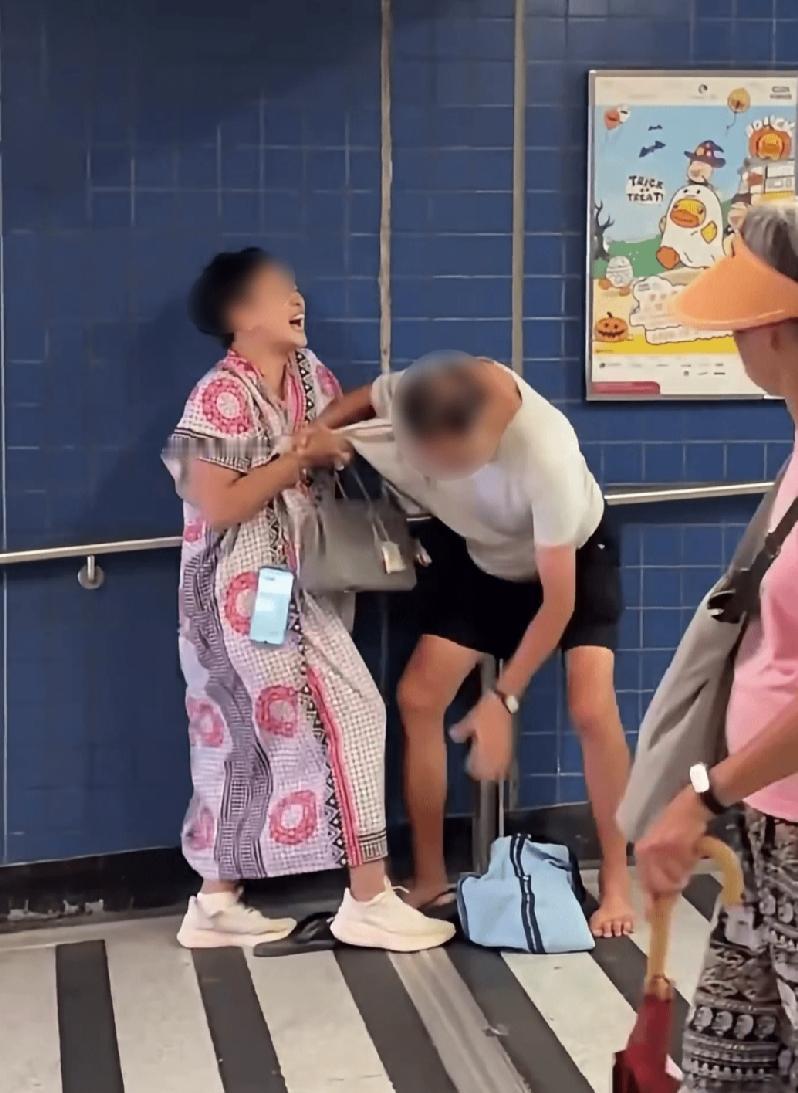 9月20号中午香港港铁大围站A出口，一名中年妇人死死拽住赤脚阿伯不放，两个人在车