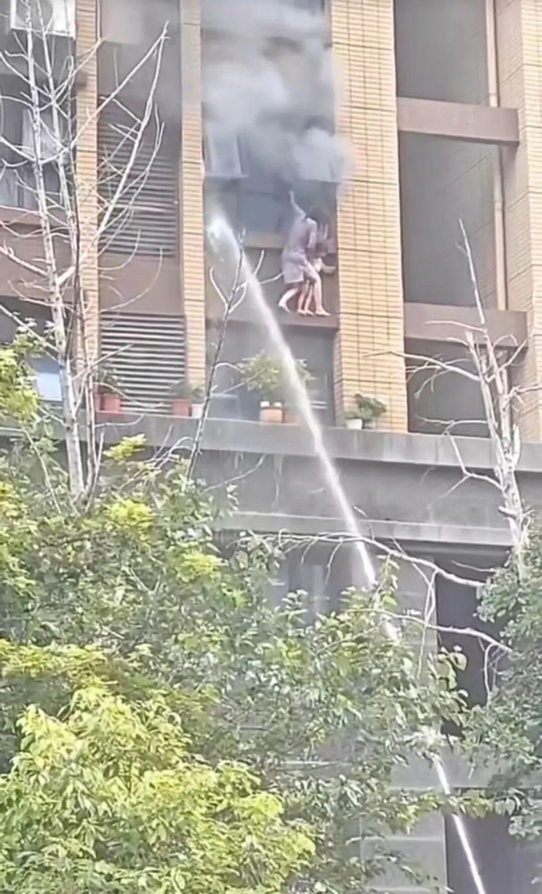一对母女在连云港火灾中站到外墙腰线等待救援，消防队赶到现场后虽努力喷水，但终未能