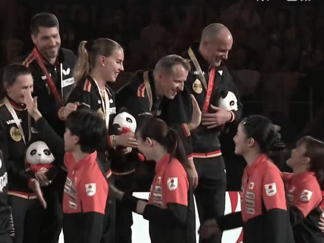 混合团体世界杯颁奖仪式上，获得亚军的日本队员先走到获得季军的德国队前面和队员们击