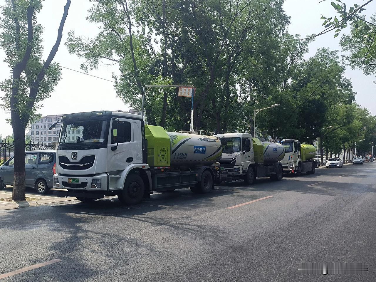 保定五四路与红阳大街交叉口附近

三辆洒水车一字排开停在红阳大街旁，头一辆在利用