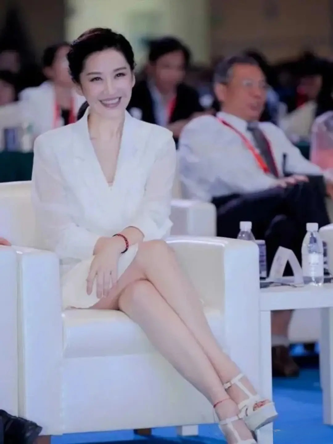 许晴真的很懂得如何把身材优势发挥到最大，盘腿而坐，一身白色西装裙的造型十分惊艳在