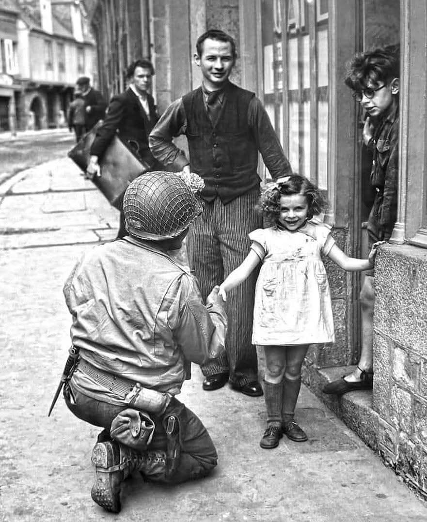 1944年，诺曼底维勒迪约莱波埃勒，一名当地小女孩与美军士兵握手。 