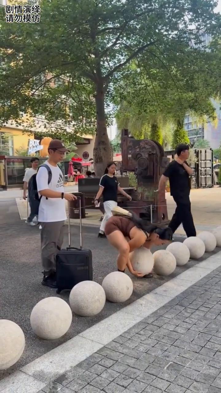 男子拉着行李箱被石墩挡住去路，下一秒女子的做法太有才了。
男子拉着行李正走路时，