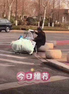 拾荒大爷算是捡到宝了!

一位拾荒老人捡到一张别人的结婚海报，大爷坐在马路边，小