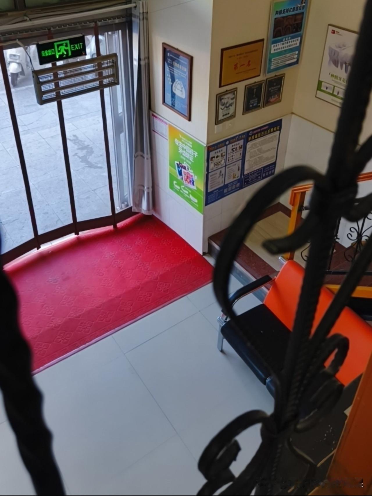 下楼路过楼下这家牙科门诊，环境收拾得干净敞亮，进门红地毯看着特别暖心。

墙上挂