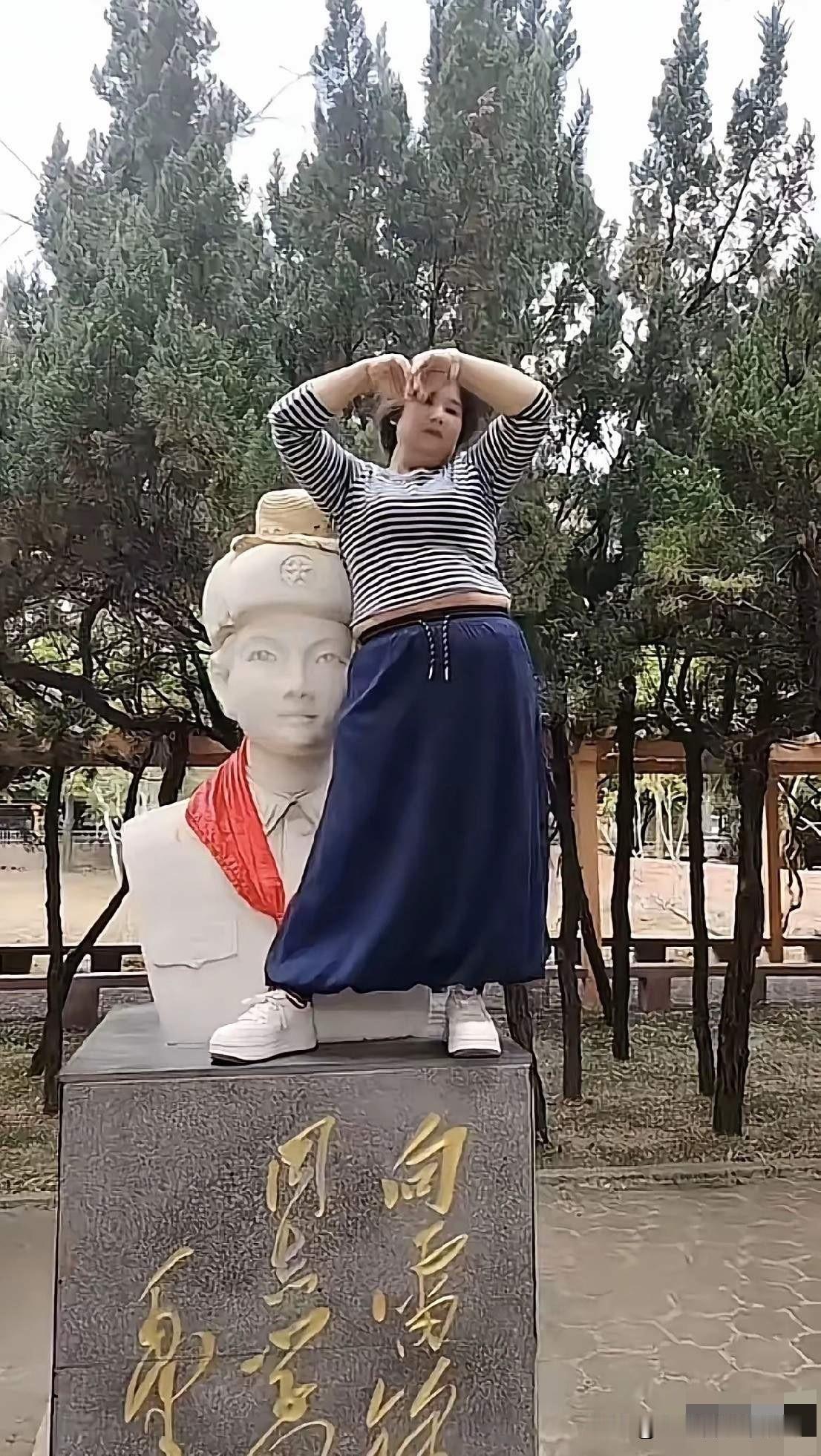 人怎么可以无知到这种程度？看这位女子的年龄也不小了，但是在烈士雕像前却没有半点敬