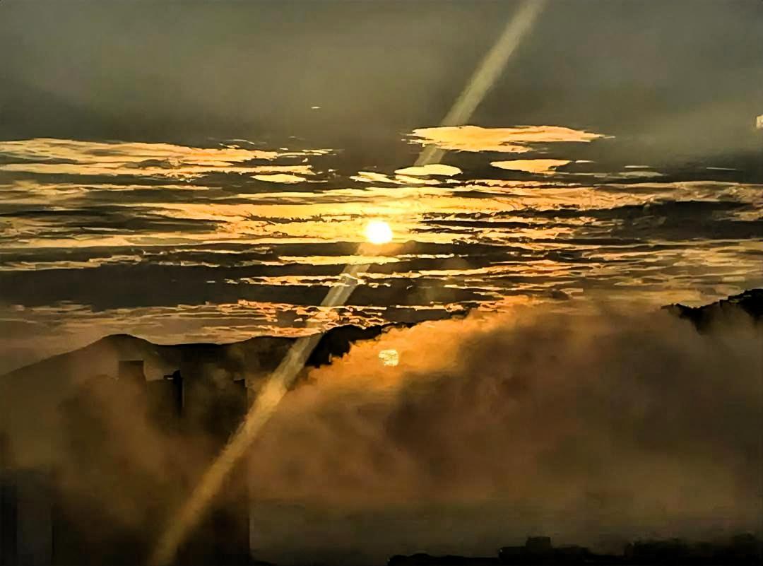 夕阳西下，云海翻滚，光影交错，如梦如幻。那橙红色的夕阳，像是被调皮的孩子打翻的颜