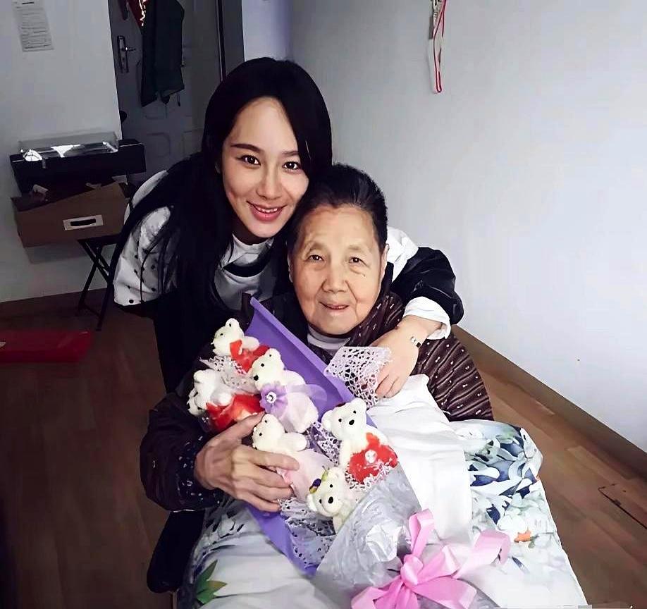 这一帧停下来的时候，暖意像从指缝里漏出来。
杨紫靠在老人身后，手臂绕过去环着长辈
