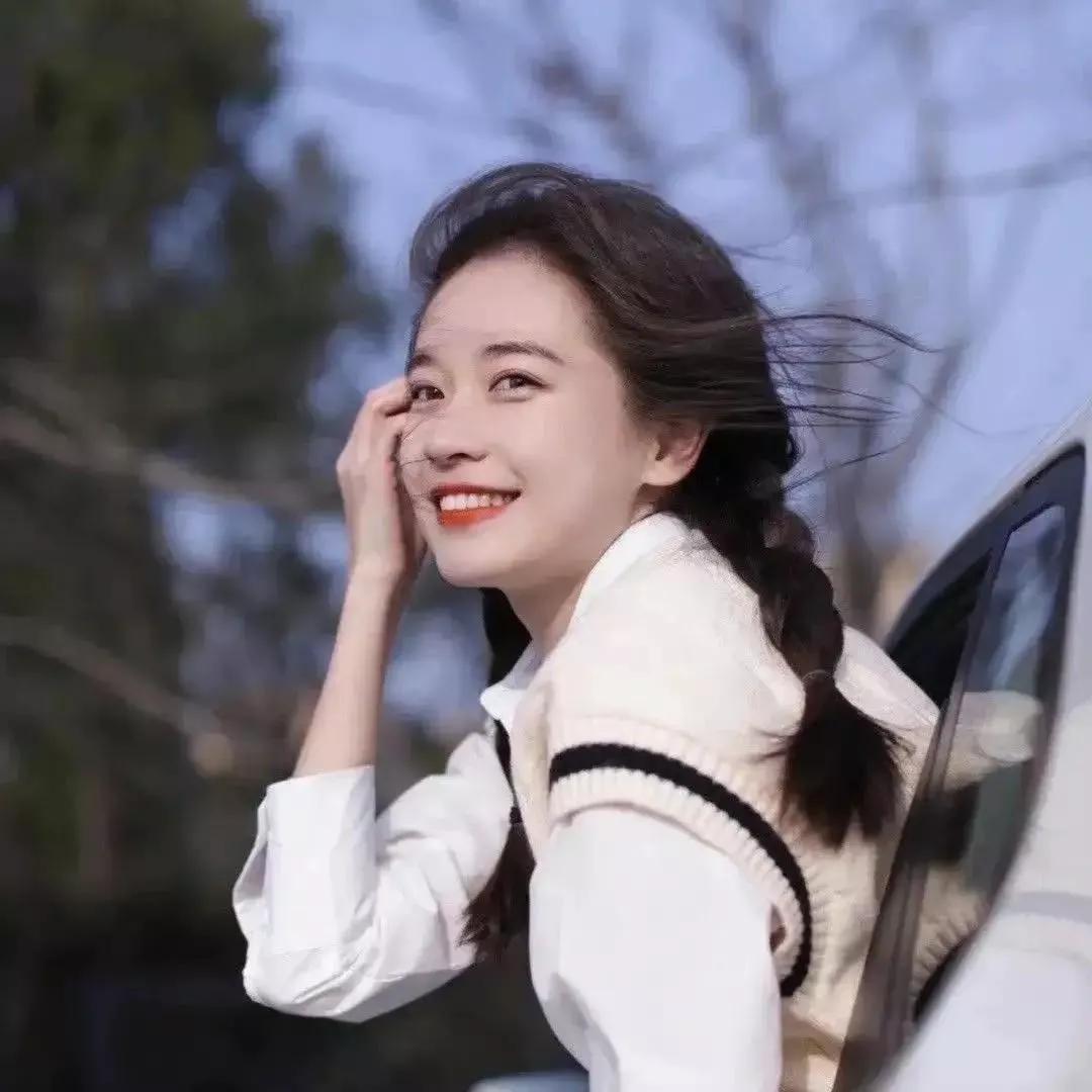微笑着靠在车窗边，阳光洒在她的脸上，温暖而美好。