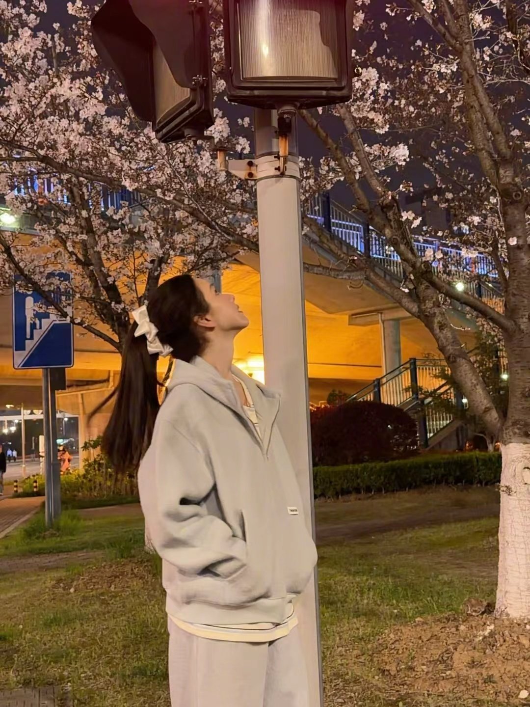 陈都灵下班偶遇春天的花  陈都灵下班偶遇春天的花  灰色卫衣高马尾造型俏皮可爱，