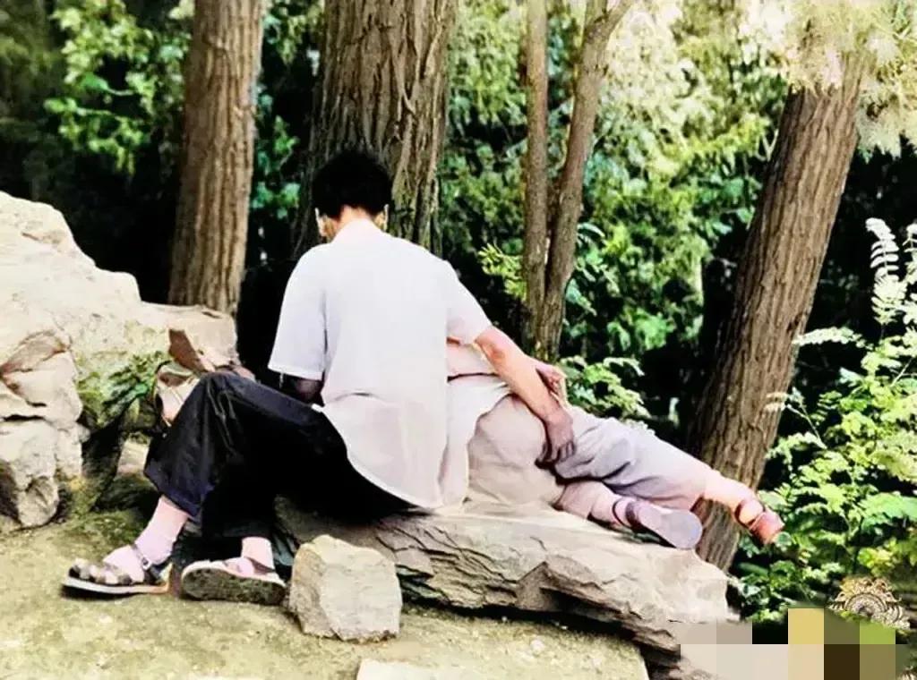 80年代，天津的公园，一对情侣，正在谈恋爱，女孩子睡在一块石头上，男孩子依偎在她