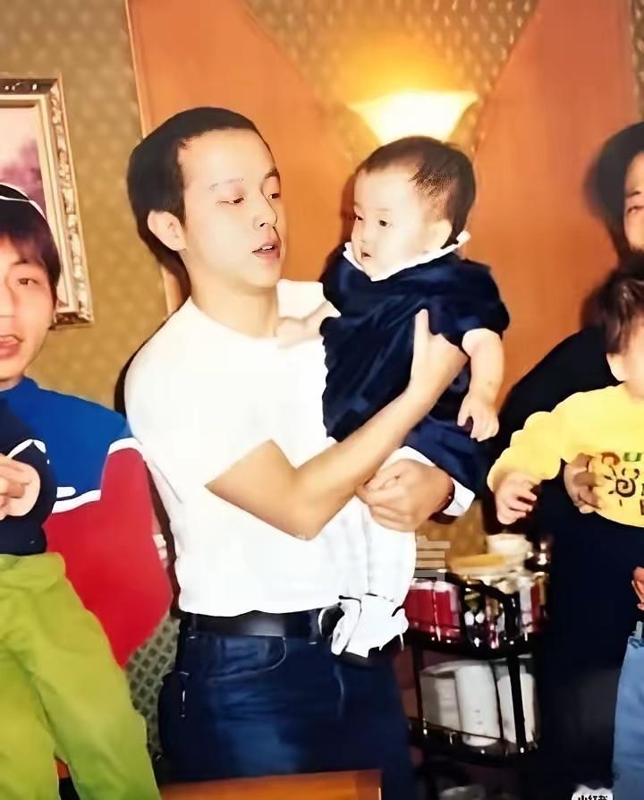 窦唯抱着还是婴儿的窦靖童。讲真，窦靖童长得像爸爸，声音像妈妈，舞台风格是爸爸和妈