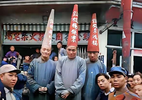 1949年11月，上海街头，杨振寰等三名旧时代“讼棍”被戴纸帽示众。他们身着长衫