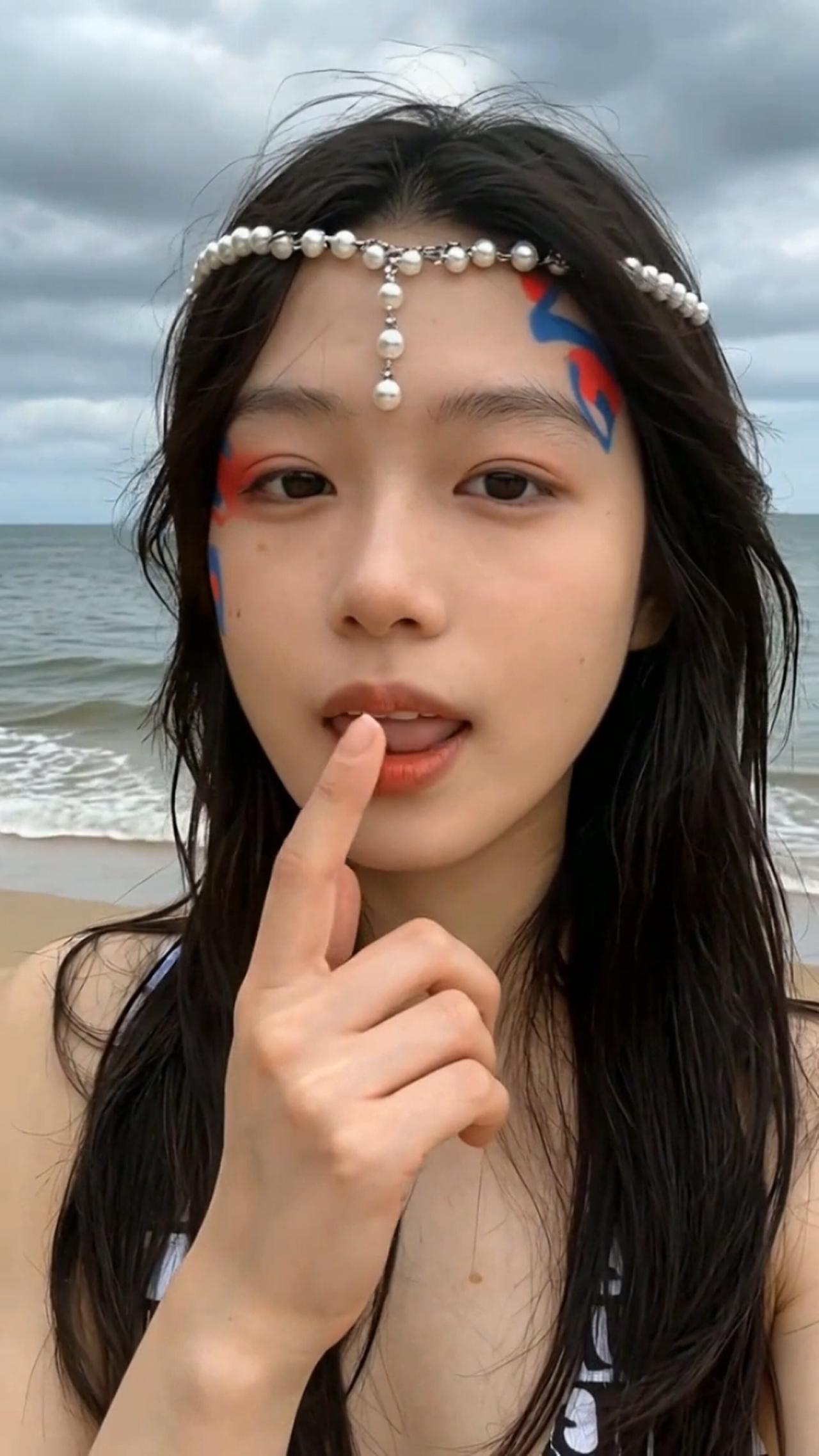 海边少女，海风吹拂，珍珠发带，蓝色眼影，海浪轻拍，宁静时光。