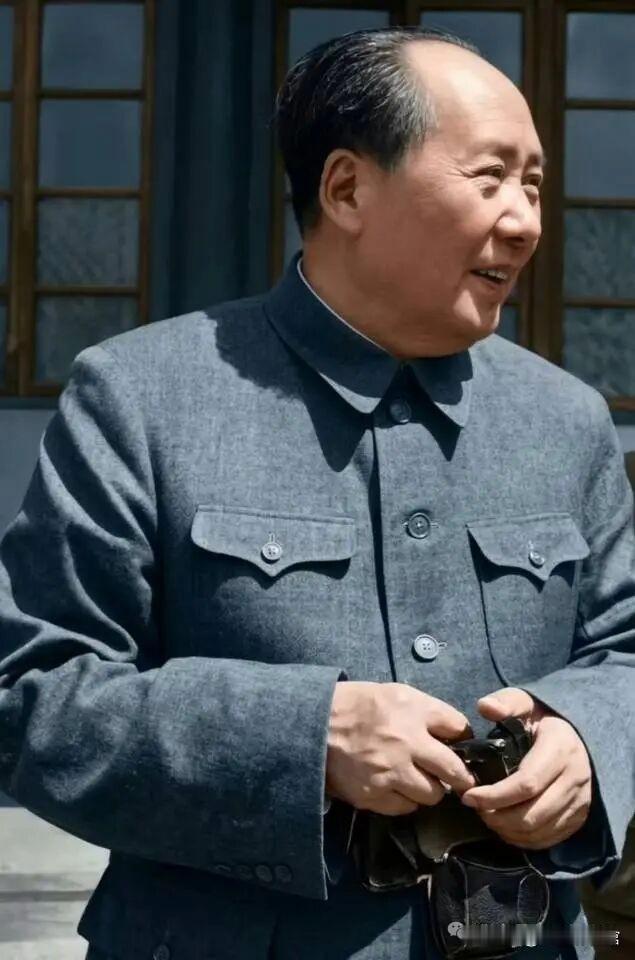 这是影视剧照，刻画建国初期的毛主席。身处办公院落，身着朴素中山装，手持物件面带笑